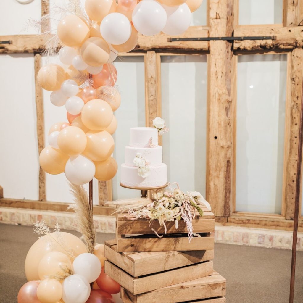 Natual barn wedding - wedding cake and balloon arch