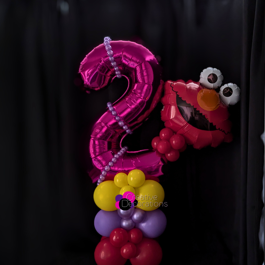 A first birthday number display with mini foil animal balloons